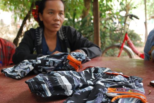 Yrittäjänainen ompelee lasten housuja Siem Reapin kylässä.