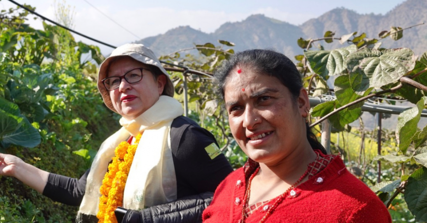 Vapaaehtoinen ja nepalilainen nainen viljelyksillä