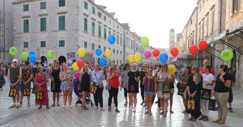 Joukko naisia seisoo värikkäät ilmapallot käsissään.