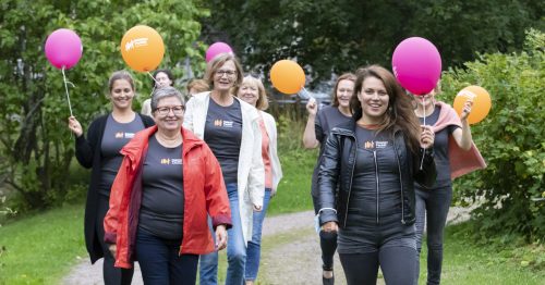 Joukko naisia kävelee ilmapallot käsissään.