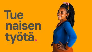 nainen seisoo sivuttain kädet lanteilla ja katsoo kameraan