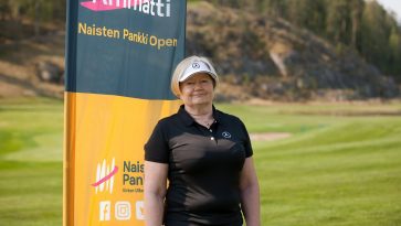 Nainen seisoo golfkentällä .