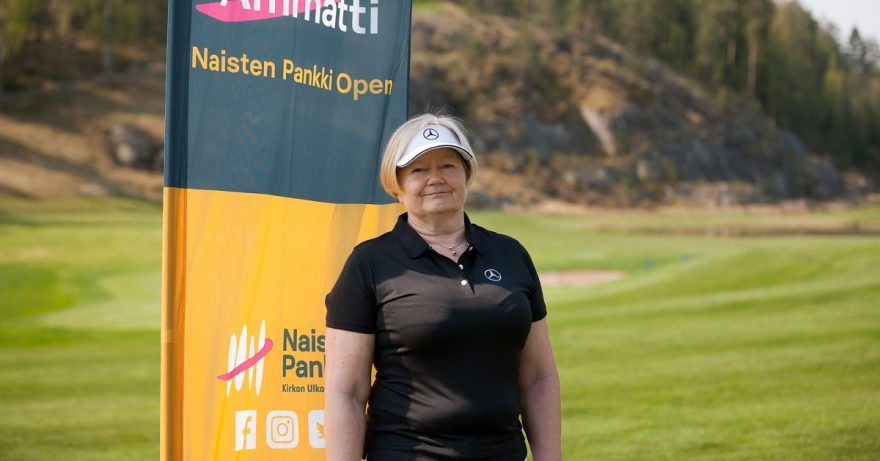 Nainen seisoo golfkentällä .