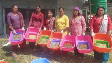 Six women pose for a photo holding trays