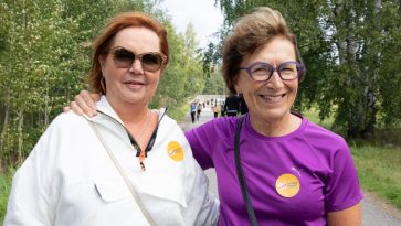 Kaksi naista vierekkäin hymyilemässä.