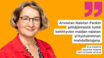 Silmälasipäinen nainen punaisessa takissa.