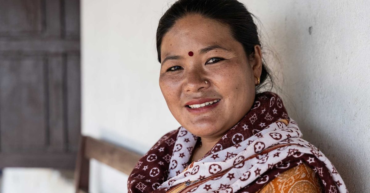 Nepalilainen nainen hymyilee kameralle.