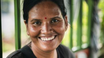 Nepalilainen nainen hymyilee leveästi.