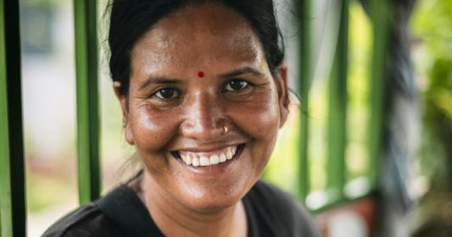 Nepalilainen nainen hymyilee leveästi.