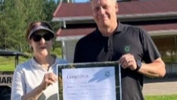 Mies ja nainen pitävät edessään kunniakirjaa.
