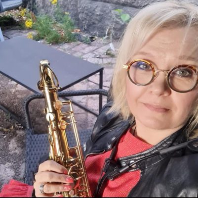 Nainen pitelee käsissään saksofonia.