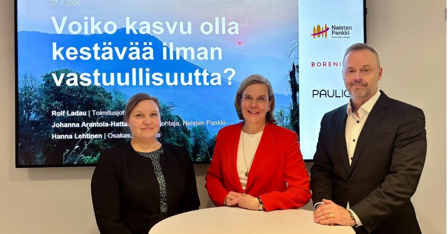 Kaksi naista ja mies seisovat pyöreän pöydän ääressä.