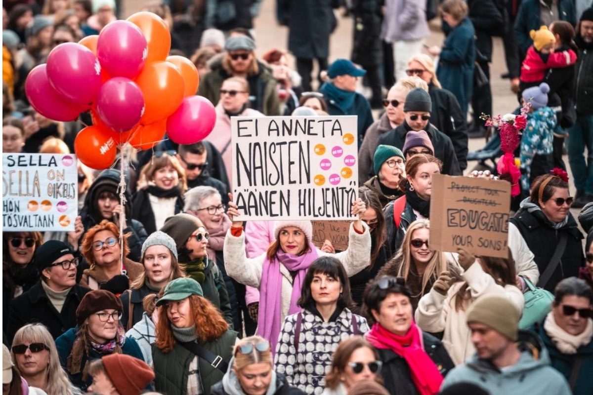 Suuri joukko naisia tekstikyltit kohotettuina.