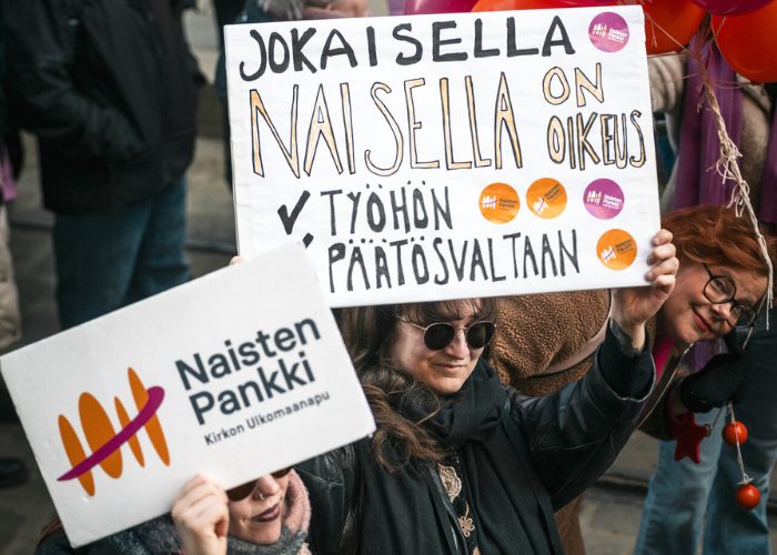 Ihmisi' pitelemässä tekstikylttejä.